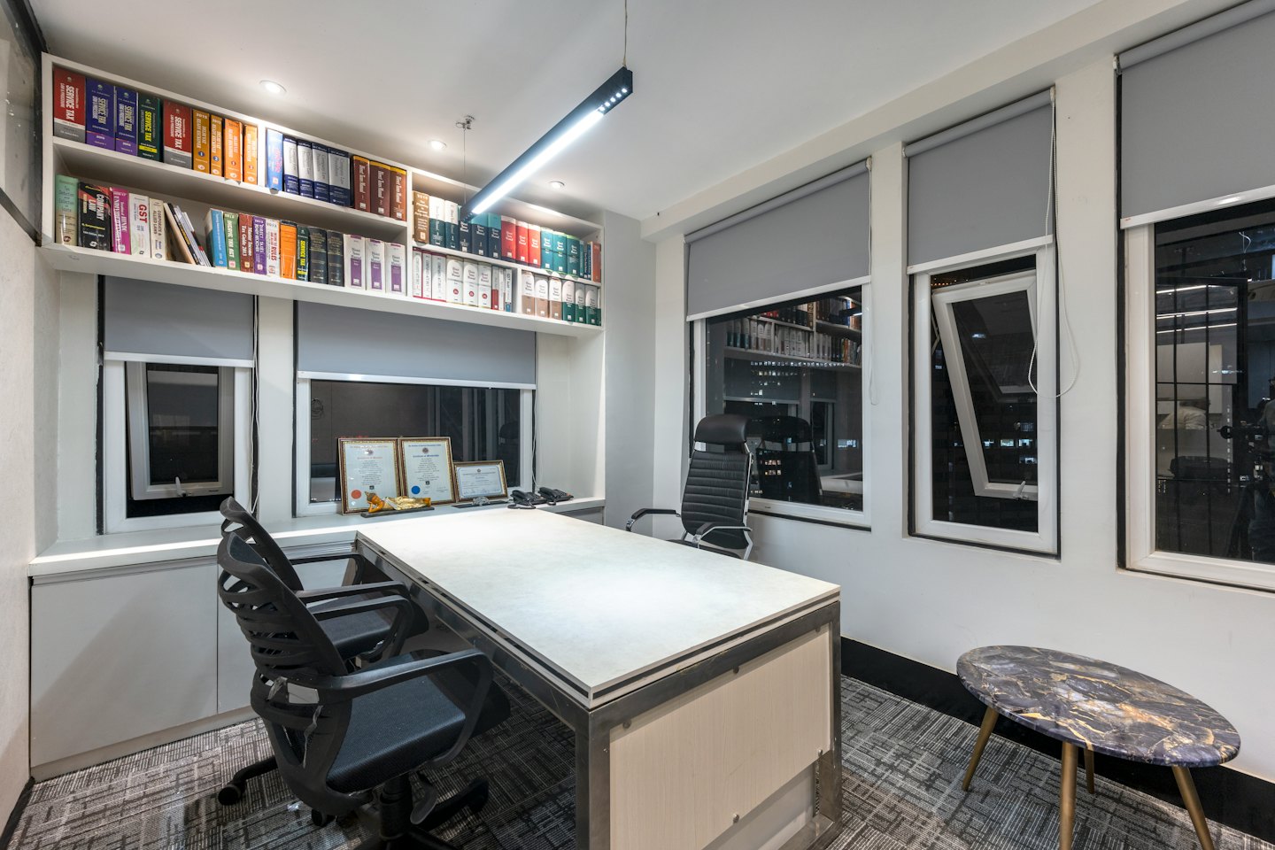 Bureau professionnel avec un grand bureau et des étagères de bibliothèque juridique.